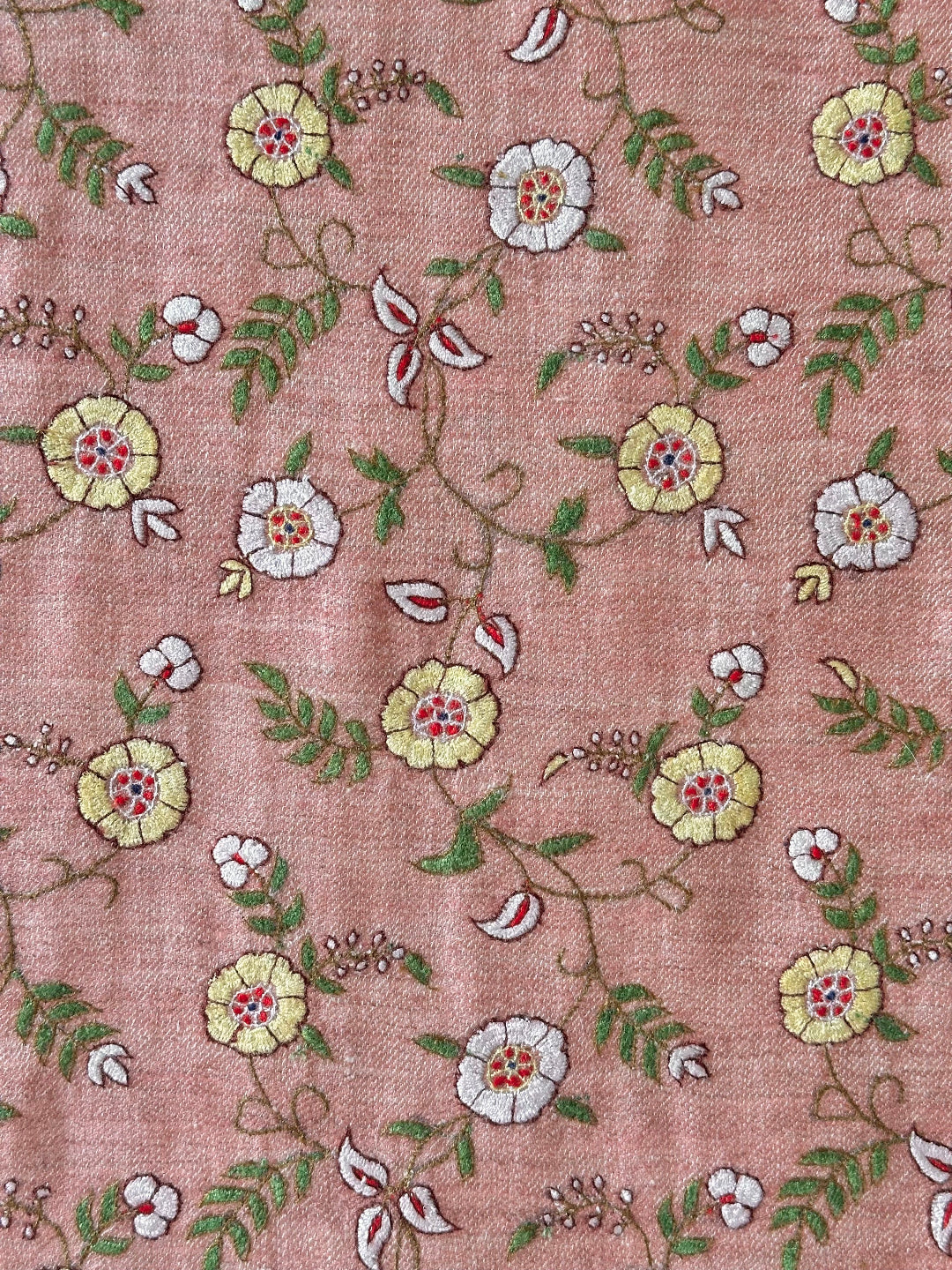 Floral embroidery pattern on fabric with a pinkish-brown background